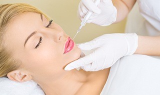 Woman receiving Juvederm injection above lip