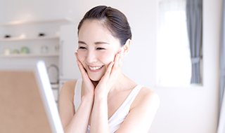 Woman looking at skin in mirror