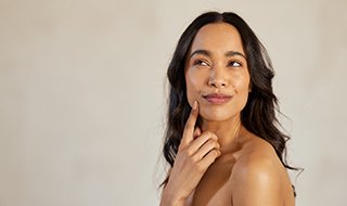 Woman with beautiful skin wearing thoughtful expression