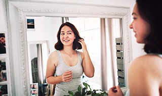 Woman confidently looking at herself in mirror