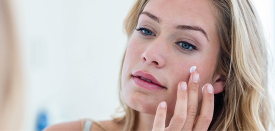 Woman applying skin care product
