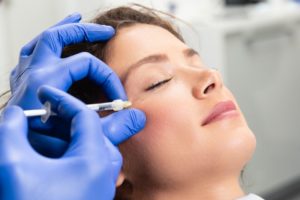 a woman with her eyes closed having a Botox injection to eliminate crow’s feet 