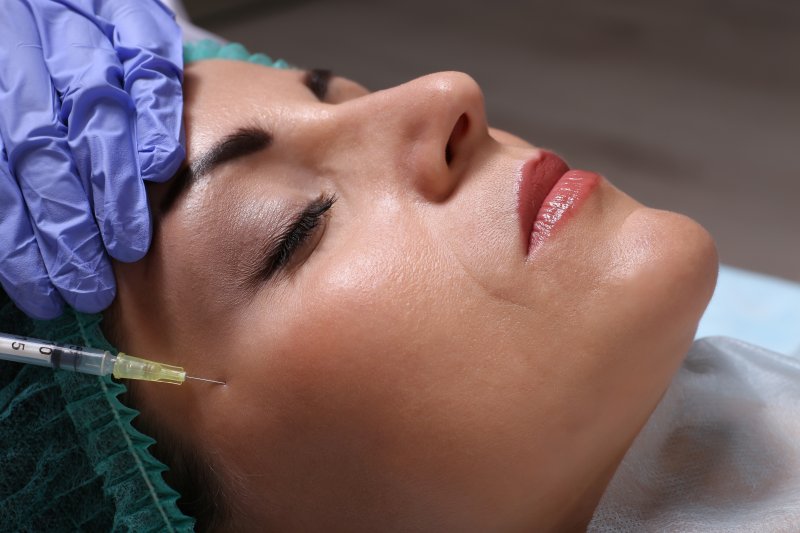 a middle-aged woman receiving dermal fillers during an appointment 