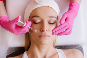 Blonde woman receiving dermal filler for lips