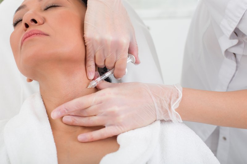 a woman receiving Botox in the neck