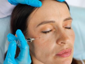 Woman receiving dermal filler injection under her eye