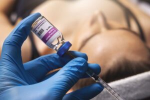 Gloved hands preparing BOTOX injection